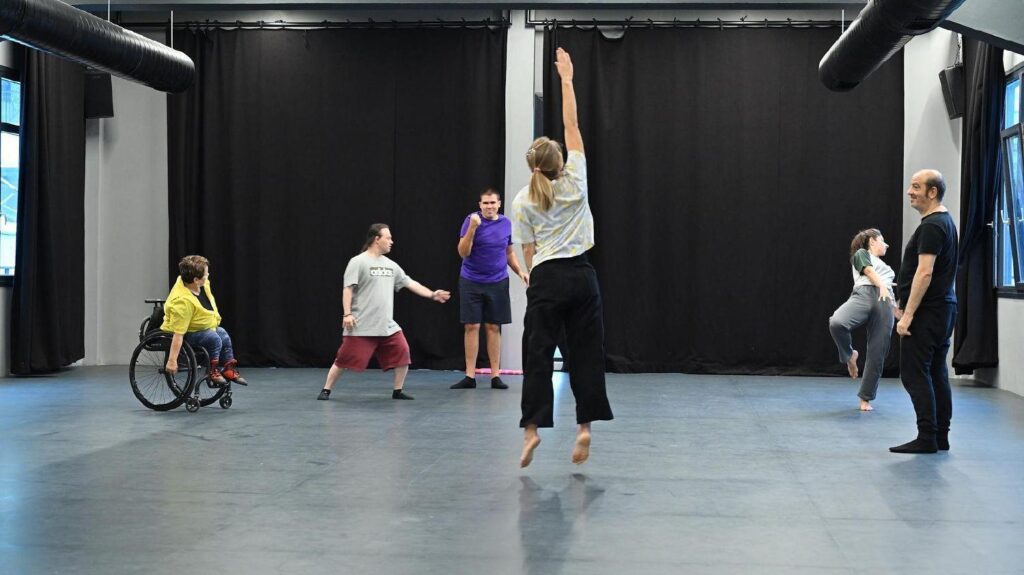In a dance studio, several performers are reharsing